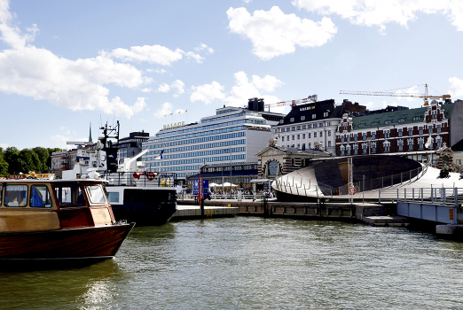 Kesäinen maisema Helsingin Etelärannasta, kuvassa Palace ja vanha puuvene lipumassa laituriin. 